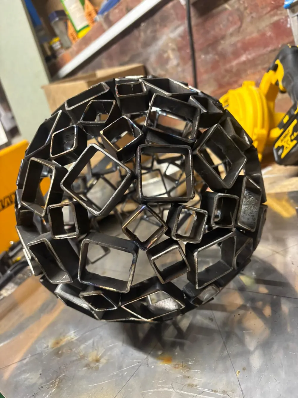 Close detail of the interconnected hand-cut steel squares.