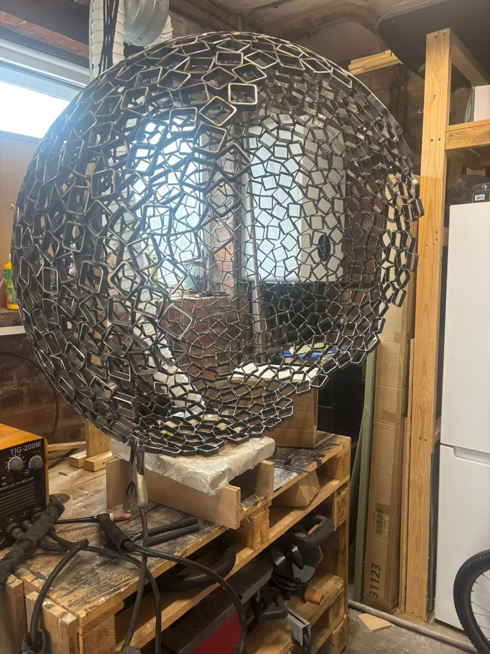 The completed steel sphere resting in the workshop.