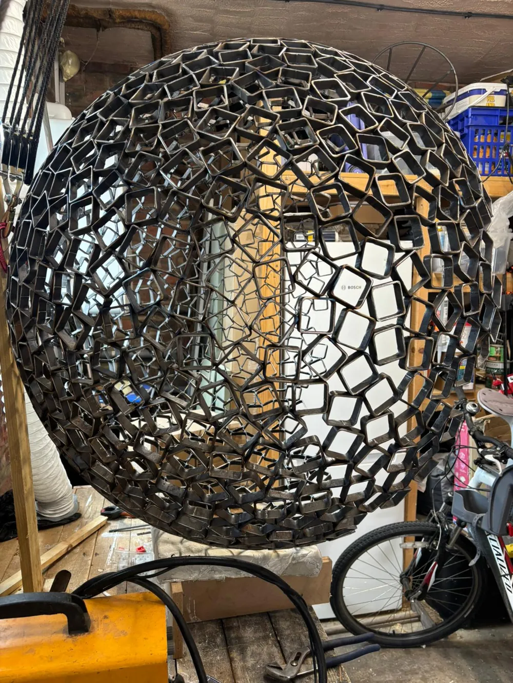 The lattice sphere backlit in the workshop.